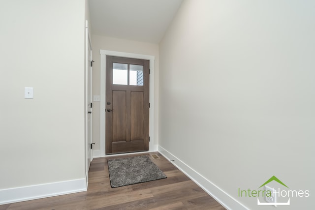 doorway to outside with vaulted ceiling and hardwood / wood-style flooring