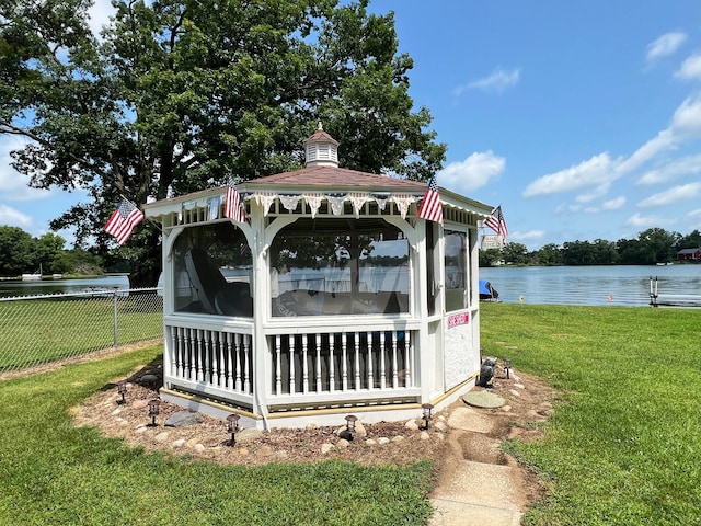 dock area featuring a water view, a gazebo, and a lawn