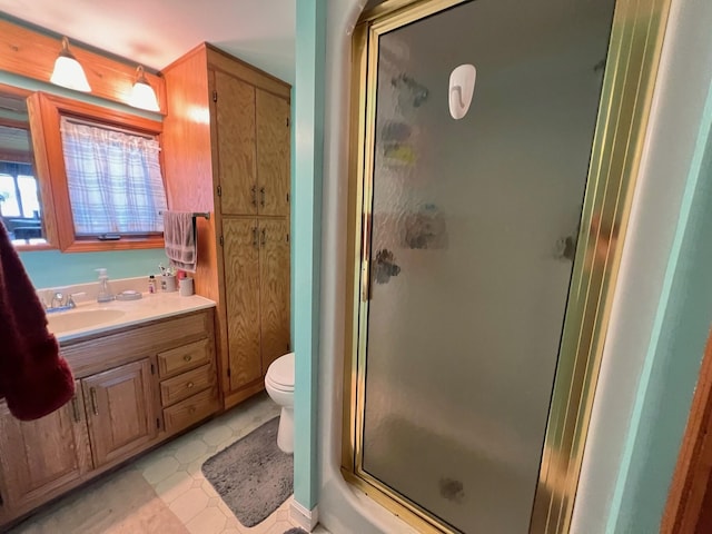 bathroom with vanity, a shower with shower door, tile patterned floors, and toilet