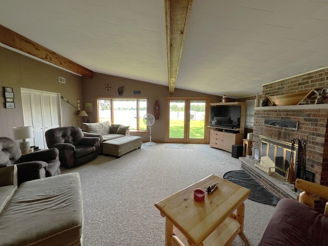 living room featuring lofted ceiling with beams, light colored carpet, and a fireplace