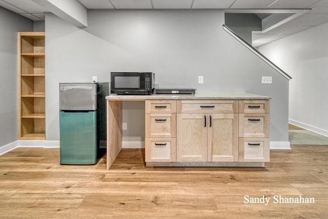 kitchen featuring a paneled ceiling, light brown cabinets, stainless steel refrigerator, and light hardwood / wood-style flooring