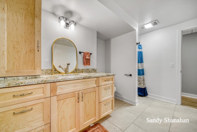 bathroom with vanity, tile patterned floors, and toilet