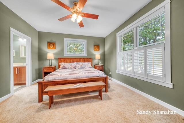 carpeted bedroom with ceiling fan and ensuite bath