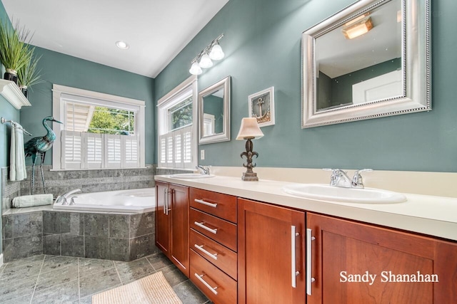 bathroom featuring vanity and tiled tub