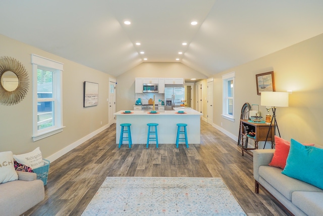 interior space featuring stainless steel refrigerator with ice dispenser, wood-type flooring, and lofted ceiling