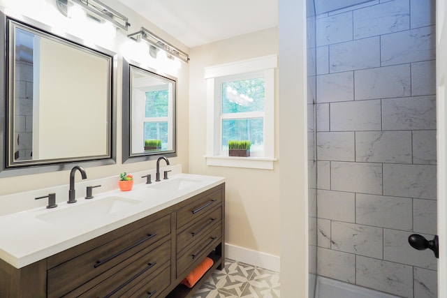 bathroom with double vanity, tile patterned flooring, and a healthy amount of sunlight