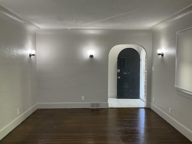 unfurnished room featuring hardwood / wood-style flooring and a textured ceiling