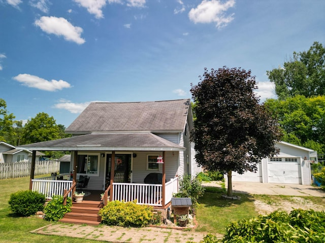 view of front of property featuring an outbuilding, a garage, a front yard, and a porch