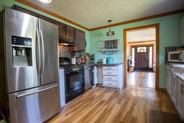 kitchen featuring tasteful backsplash, light hardwood / wood-style flooring, ornamental molding, appliances with stainless steel finishes, and pendant lighting