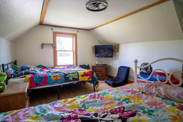 bedroom with vaulted ceiling, hardwood / wood-style floors, and a textured ceiling