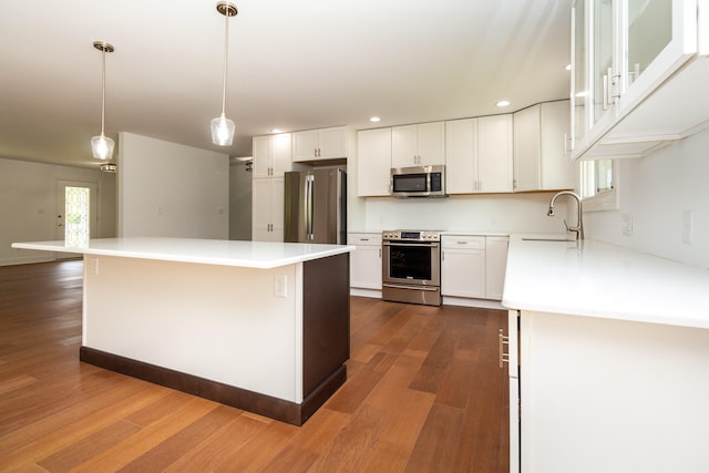 kitchen featuring stainless steel appliances, dark hardwood / wood-style floors, and white cabinetry