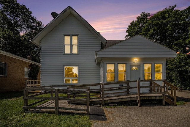 back of property at dusk featuring a deck