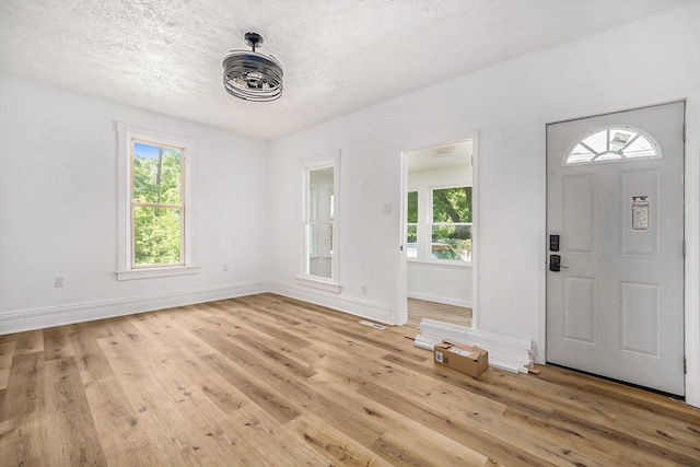 entrance foyer with a textured ceiling and light wood-type flooring