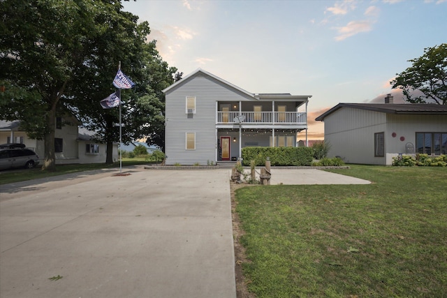 view of front of home featuring a balcony and a lawn