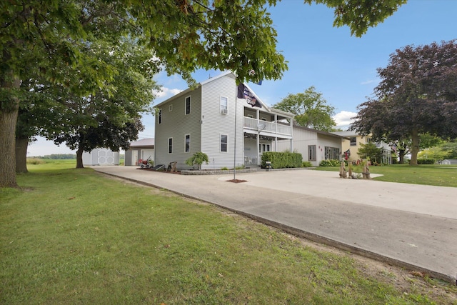 view of front of house with a front yard and a balcony