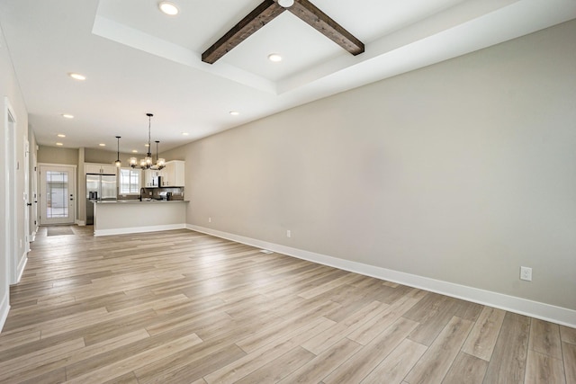 unfurnished living room featuring beam ceiling, light wood-type flooring, and a chandelier