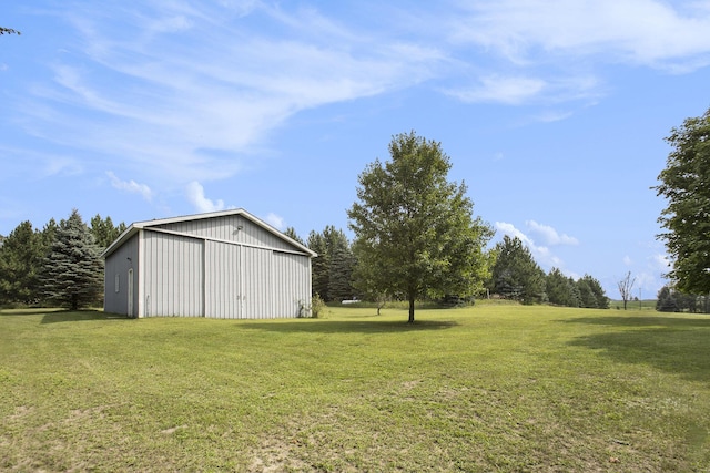 view of yard featuring a detached garage, an outbuilding, and a pole building