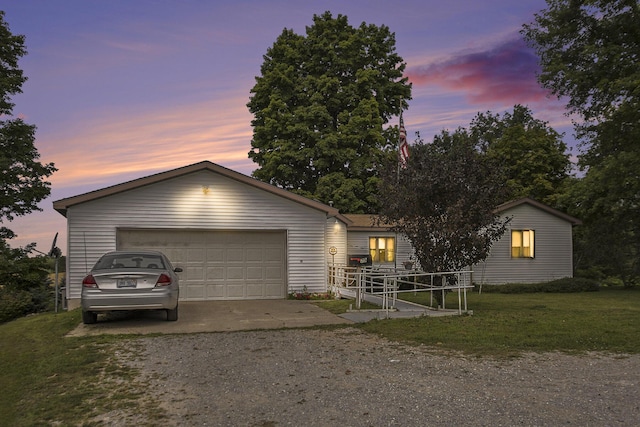 ranch-style house with a garage, a yard, and driveway