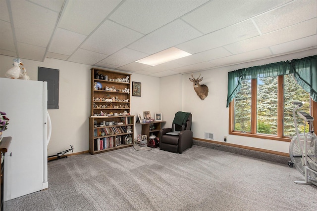 living area featuring visible vents, baseboards, carpet floors, electric panel, and a paneled ceiling