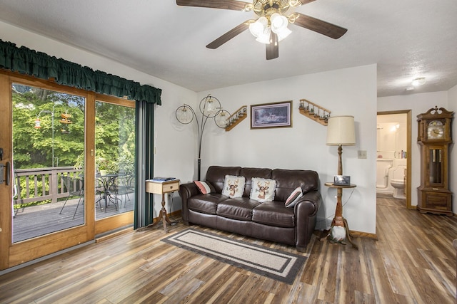 living area featuring a ceiling fan, baseboards, and wood finished floors