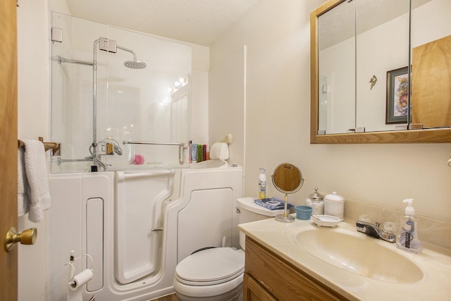 full bath featuring vanity, walk in shower, a textured ceiling, toilet, and a washtub