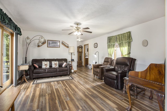 living area with ceiling fan, wood finished floors, and a textured ceiling