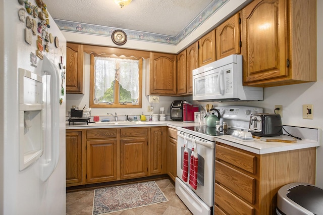 kitchen featuring white appliances, brown cabinetry, and light countertops