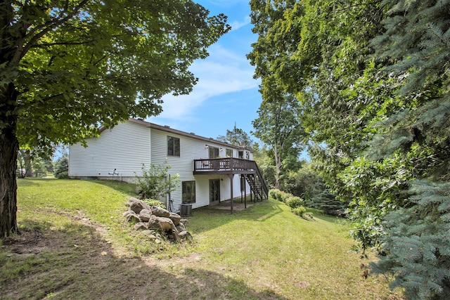 view of yard with cooling unit, stairs, and a deck