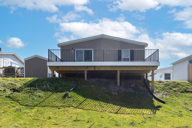 rear view of house featuring a wooden deck and a yard