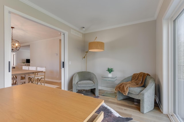 interior space featuring crown molding, an inviting chandelier, and light hardwood / wood-style flooring