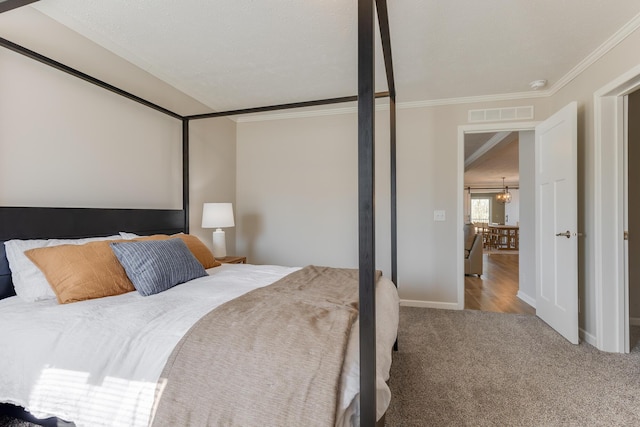 bedroom with ornamental molding, carpet floors, and a chandelier