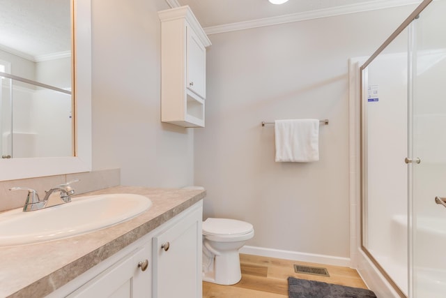 bathroom featuring hardwood / wood-style flooring, vanity, an enclosed shower, toilet, and crown molding