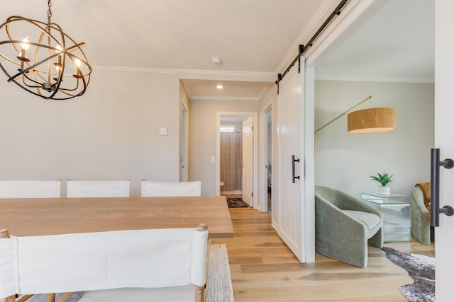 interior space with crown molding, a barn door, an inviting chandelier, and light wood-type flooring