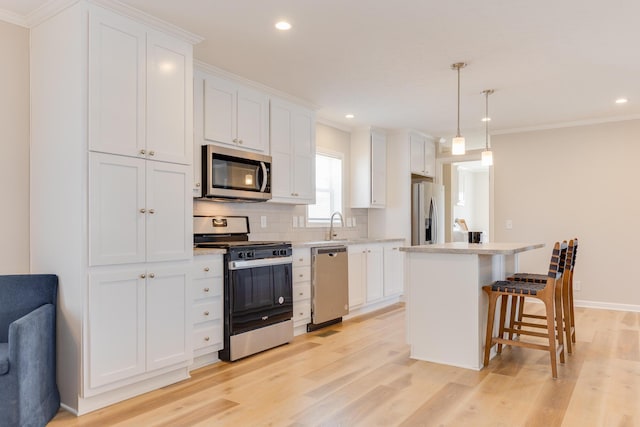 kitchen with a kitchen island, white cabinets, and appliances with stainless steel finishes