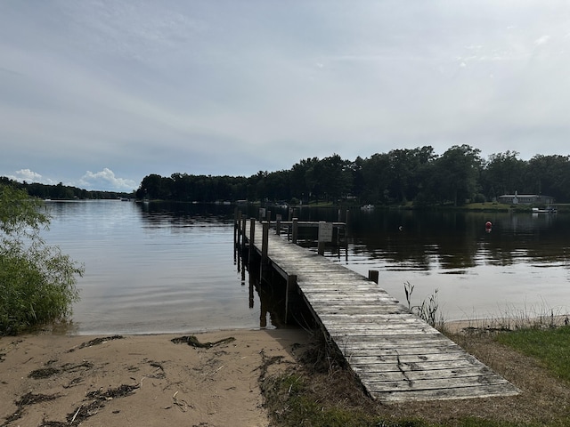 dock area with a water view and a wooded view