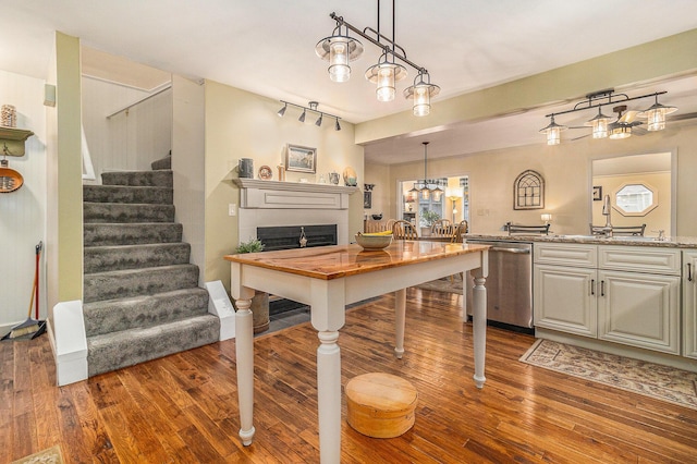 dining room featuring stairs, a fireplace, and dark wood finished floors