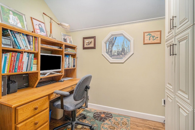 office area with light wood-style floors, baseboards, and vaulted ceiling