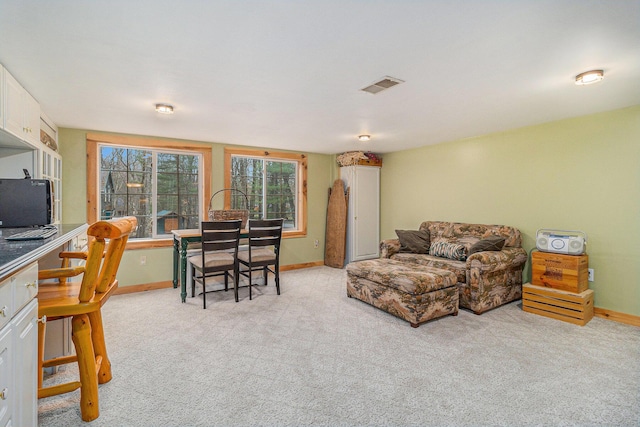 living room with baseboards, visible vents, and light colored carpet