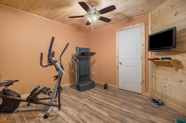 workout room featuring wood walls, wooden ceiling, wood finished floors, and a ceiling fan