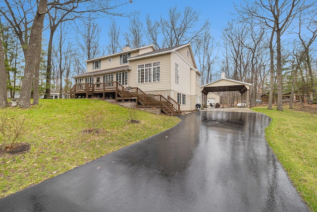 view of front of property featuring stairway, a front yard, driveway, and a chimney