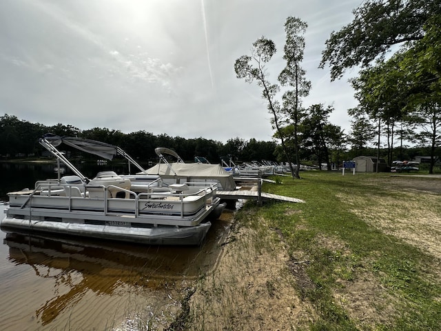 dock area with a water view and a lawn