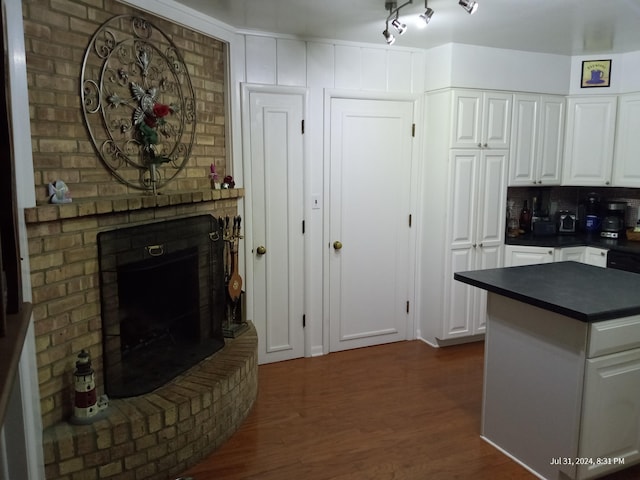 kitchen featuring dark hardwood / wood-style floors, white cabinets, and a fireplace