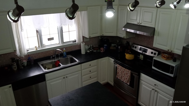 kitchen with stainless steel appliances, white cabinetry, hanging light fixtures, and sink