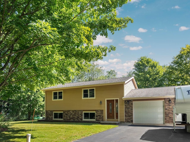 split foyer home featuring a garage and a front yard