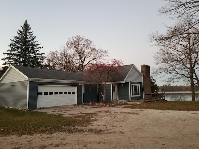 view of front of house with a garage and a water view