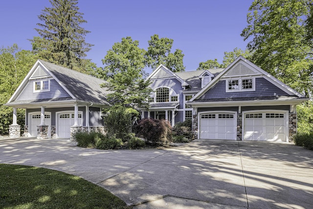 shingle-style home featuring stone siding and a garage