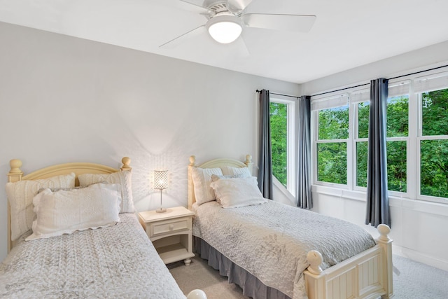 bedroom featuring baseboards, light carpet, and a ceiling fan