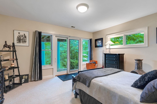 carpeted bedroom with access to outside, multiple windows, and visible vents