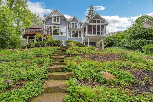 back of house with stairway and a sunroom