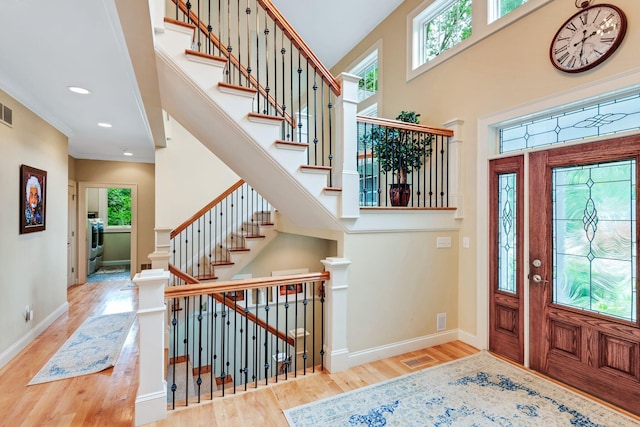 entrance foyer with a high ceiling, baseboards, and wood finished floors